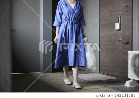 玄関を開けてゴミ出しに向かう女性 玄関を開けてゴミ出しに向かう女性 142131585