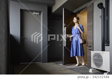 バッグを持ってマンションを出る女性 バッグを持ってマンションを出る女性 142131588