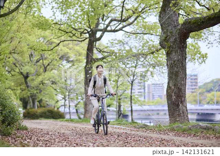 木々の間を自転車で移動する女性 142131621