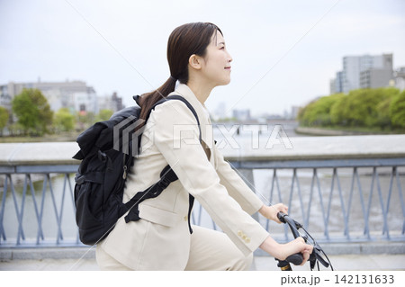 橋を正面から自転車で通勤する女性 橋を正面から自転車で通勤する女性 142131633