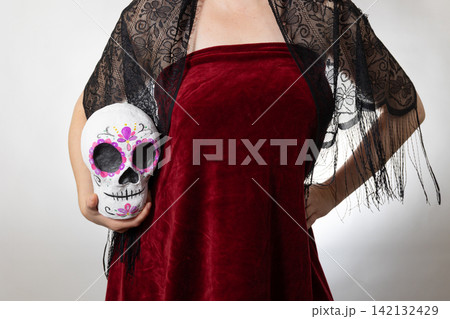 Vibrant Day of the Dead portrait with decorated sugar skull and burgundy velvet dress Vibrant Day of the Dead portrait with decorated sugar skull and burgundy velvet dress 142132429