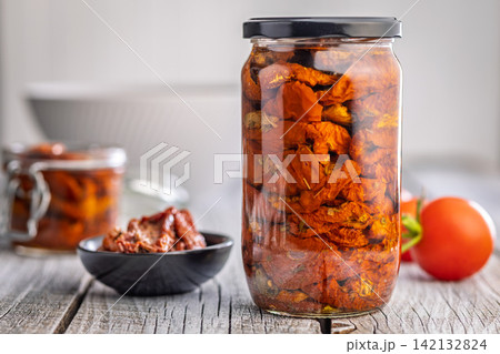 Jar of Sun-Dried Tomatoes in Oil on Rustic Wooden Table With Bowl and Fresh Tomatoes Jar of Sun-Dried Tomatoes in Oil on Rustic Wooden Table With Bowl and Fresh Tomatoes 142132824