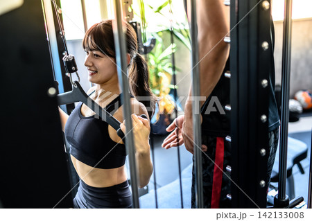 ラットプルダウンで体を鍛える女性 ジムでトレーナーの指示を受ける 昼カラーアート ラットプルダウンで体を鍛える女性 ジムでトレーナーの指示を受ける 昼カラーアート 142133008