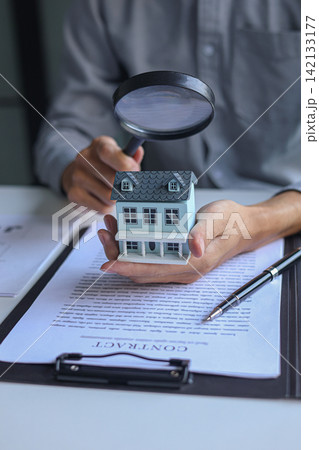 Home buyer inspecting new house details and contract before signing Home buyer inspecting new house details and contract before signing 142133177