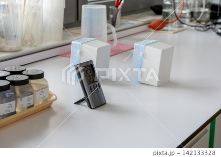 labeled water sample bottles, digital thermometer and plastic boxes in laboratory labeled water sample bottles, digital thermometer and plastic boxes in laboratory 142133328