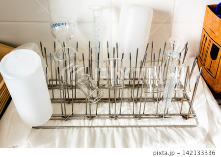 laboratory glassware drying on metal rack in science lab laboratory glassware drying on metal rack in science lab 142133336