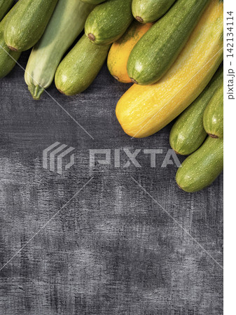 Colorful zucchini displayed on wood against a farm background, representing organic food, fresh produce, and natural farming. Colorful zucchini displayed on wood against a farm background, representing organic food, fresh produce, and natural farming. 142134114