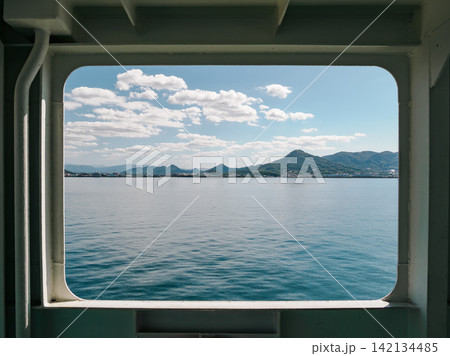 フェリーの船窓から見る晴れた日の瀬戸内海と香川県の旅の風景 フェリーの船窓から見る晴れた日の瀬戸内海と香川県の旅の風景 142134485