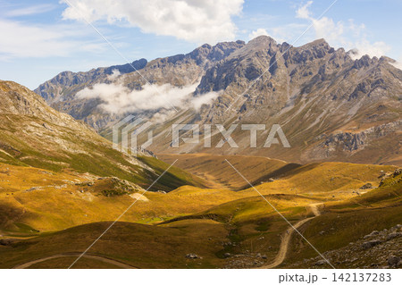 View of the Picos de Europa mountains against the background of a blue sky with clouds View of the Picos de Europa mountains against the background of a blue sky with clouds 142137283