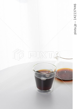 おうちカフェのイメージ｜白を基調とした部屋に置かれたアイスコーヒーと二重グラス 142137446