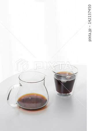 おうちカフェのイメージ｜白を基調とした部屋に置かれたアイスコーヒーと二重グラス 142137450