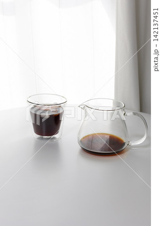 おうちカフェのイメージ｜白を基調とした部屋に置かれたアイスコーヒーと二重グラス 142137451