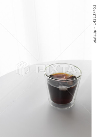 おうちカフェのイメージ｜白を基調とした部屋に置かれたアイスコーヒーと二重グラス 142137453
