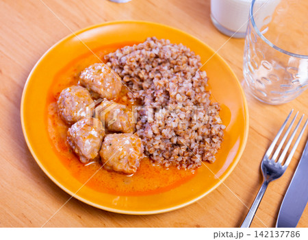Meatballs in sauce served with buckwheat 142137786