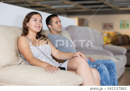Couple trying out couch while choosing furniture in store Couple trying out couch while choosing furniture in store 142137862