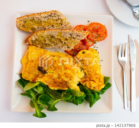 Omelet with bread and salad on a plate 142137908