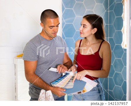 Husband and wife together choose color of ceramic tiles according to color patterns Husband and wife together choose color of ceramic tiles according to color patterns 142137957