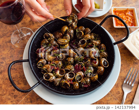 Female hands and pot of snails 142137994