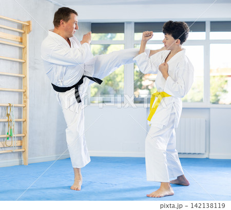 Man and teenage boy training karate fight 142138119