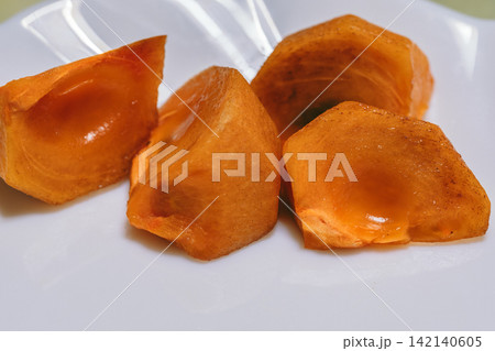 白い皿に盛り付けた食べ頃の柿 白い皿に盛り付けた食べ頃の柿 142140605