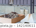 木箱に入れた土付きの里芋と作業用長靴 142140611
