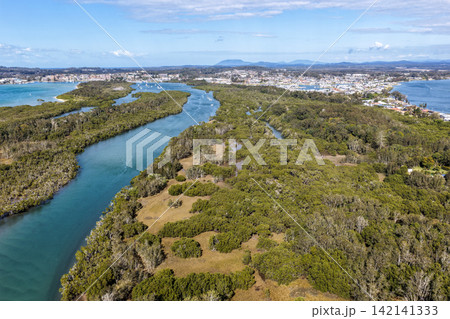 Aerial view from Settlement Point looking along the Hastings River towards Port Macquarie, showcasing the broad waterway, foreshore, surrounding coastal landscape and urban area in the distance Aerial view from Settlement Point looking along the Hastings River towards Port Macquarie, showcasing the broad waterway, foreshore, surrounding coastal landscape and urban area in the distance 142141333
