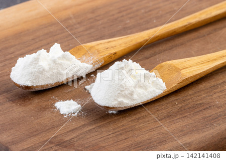 white Cornstarch Powder in Ceramic Bowl with Wooden Spoon 142141408