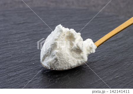 white Cornstarch Powder in Ceramic Bowl with Wooden Spoon 142141411