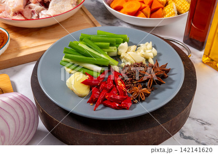 whole Spices Garlic Ginger and Scallions on Plate 142141620
