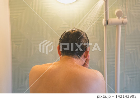シャワーで髪をすすぐ40代男性のヘアシャンプー シャワーで髪をすすぐ40代男性のヘアシャンプー 142142905
