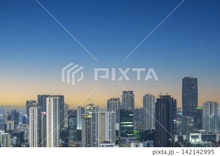 Scenic view of a modern Jakarta metropolis skyline featuring skyscrapers under a clear blue and gold twilight sky at dusk. Cityscapes background Scenic view of a modern Jakarta metropolis skyline featuring skyscrapers under a clear blue and gold twilight sky at dusk. Cityscapes background 142142995