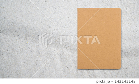 Blank brown kraft notebook on light textured grey surface with copy space 142143148