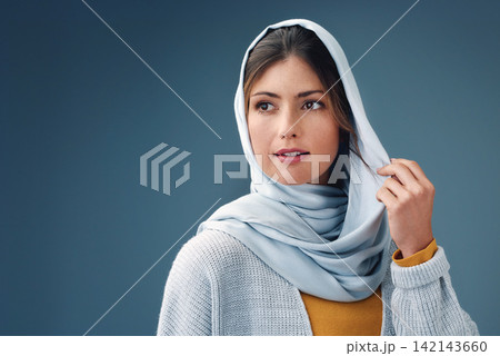 Thinking, fashion and muslim woman with idea in studio isolated on a blue background mockup space. Serious, dream and Islamic person in hijab for vision, inspiration or decision with casual clothes Thinking, fashion and muslim woman with idea in studio isolated on a blue background mockup space. Serious, dream and Islamic person in hijab for vision, inspiration or decision with casual clothes 142143660