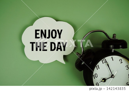 Enjoy The Day text on speech bubble with alarm clock on green background 142143835