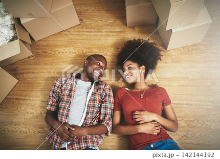 Relax, moving and happy couple on floor in new house with boxes, talking and mortgage with high angle. Smile, black man and woman in home together with future planning, love and property investment Relax, moving and happy couple on floor in new house with boxes, talking and mortgage with high angle. Smile, black man and woman in home together with future planning, love and property investment 142144192