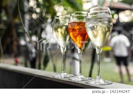 different iced spritzer wine cocktail drinks at outdoor garden bar party on sunny day different iced spritzer wine cocktail drinks at outdoor garden bar party on sunny day 142144247