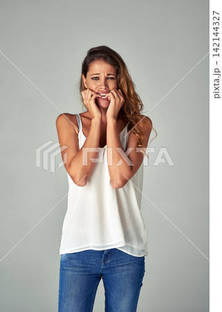 Woman, portrait and biting nails or nervous in studio with anxiety disorder, mistake or worried. Female person, face and stressed fear on grey background or scared conflict, mockup space or phobia Woman, portrait and biting nails or nervous in studio with anxiety disorder, mistake or worried. Female person, face and stressed fear on grey background or scared conflict, mockup space or phobia 142144327