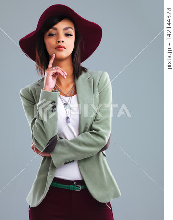 Fashion, serious and portrait of woman in studio with trendy clothes, stylish and elegant outfit. Confident, attractive and isolated person with pride in style, hat and accessory on blue background Fashion, serious and portrait of woman in studio with trendy clothes, stylish and elegant outfit. Confident, attractive and isolated person with pride in style, hat and accessory on blue background 142144328