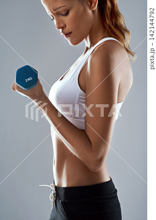 Dumbbell, weightlifting and woman for fitness in studio, health and wellness with muscle training on grey background. Exercise, strong athlete and equipment for workout with body, sport and challenge 142144792