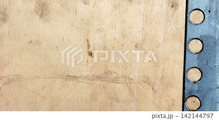 Light colored plywood panel with perforated metal frame on the right side. Light colored plywood panel with perforated metal frame on the right side. 142144797