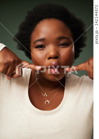 Comic, black woman and funny fish face in studio for comedy or joke isolated on green background. Portrait, lips and crazy model with facial expression, goofy or silly young plus size African student Comic, black woman and funny fish face in studio for comedy or joke isolated on green background. Portrait, lips and crazy model with facial expression, goofy or silly young plus size African student 142144872