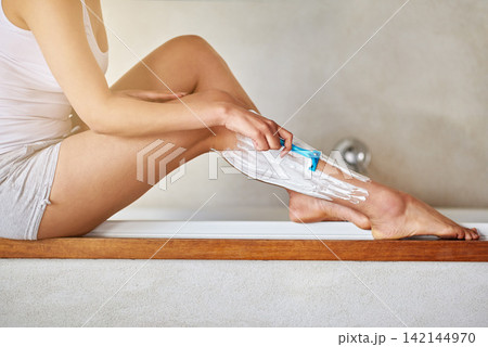 Woman, legs and epilation with shave for grooming, hygiene or hair removal in bathroom at home. Hands of female person or body with razor blade, cream or lotion in depilation treatment for skincare Woman, legs and epilation with shave for grooming, hygiene or hair removal in bathroom at home. Hands of female person or body with razor blade, cream or lotion in depilation treatment for skincare 142144970