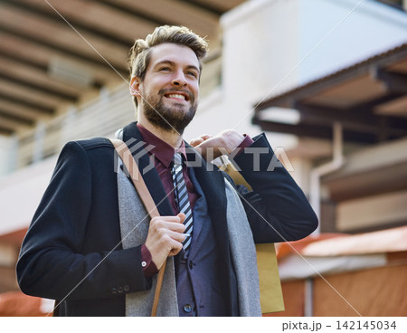 Businessman, happy and shopping in city for fashion, style and clothes with bag in street. Male person, smile and thrifting in New York for weekend, work and suit for interview in urban area 142145034