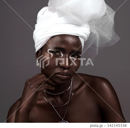 Portrait, wrap and black woman with makeup, beauty and confidence in studio on grey background. Face, glow and proud African model with traditional outfit, eyeshadow cosmetics or creative necklace Portrait, wrap and black woman with makeup, beauty and confidence in studio on grey background. Face, glow and proud African model with traditional outfit, eyeshadow cosmetics or creative necklace 142145336