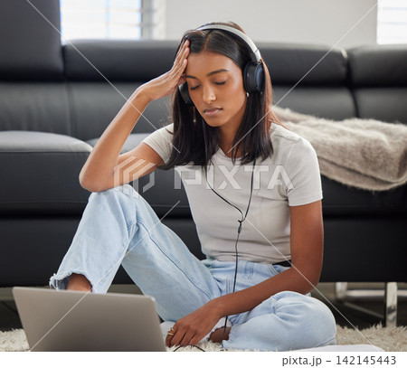 Headphones, stress and woman with laptop at home with burnout from university project and headache. Study, exam learning and tech with college student with a deadline for web class assignment Headphones, stress and woman with laptop at home with burnout from university project and headache. Study, exam learning and tech with college student with a deadline for web class assignment 142145443