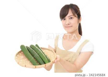 新鮮なきゅうりを持つ女性 新鮮なきゅうりを持つ女性 142145684