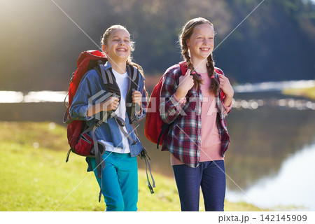 Girls, nature and backpack for walk, river and exercise for outdoor travel holiday. Fitness, smile or hobby for excited children friends, camping or vacation or weekend trip to countryside of England Girls, nature and backpack for walk, river and exercise for outdoor travel holiday. Fitness, smile or hobby for excited children friends, camping or vacation or weekend trip to countryside of England 142145909