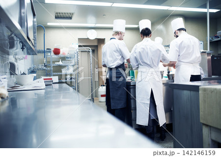People, chef and teamwork in culinary kitchen or food prepare with rear view, professional or hospitality. Collaboration, employee and hotel restaurant or dinner service or counter, cooking or meal 142146159