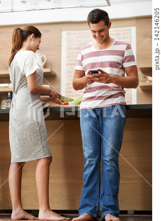 Happy couple, cooking and phone for recipe in kitchen with healthy food for balanced diet. Love, man and woman with vegetables, nutrition and organic produce for preparing meal or dinner together in Happy couple, cooking and phone for recipe in kitchen with healthy food for balanced diet. Love, man and woman with vegetables, nutrition and organic produce for preparing meal or dinner together in 142146205