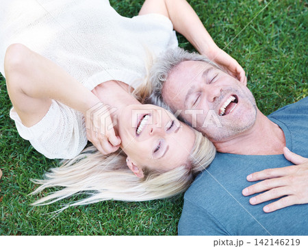 Man, woman and mature or laughing outdoor on grass field for funny joke or comedy, connection or top view. Happy couple, relax and backyard in Australia for relationship bonding, nature or together Man, woman and mature or laughing outdoor on grass field for funny joke or comedy, connection or top view. Happy couple, relax and backyard in Australia for relationship bonding, nature or together 142146219